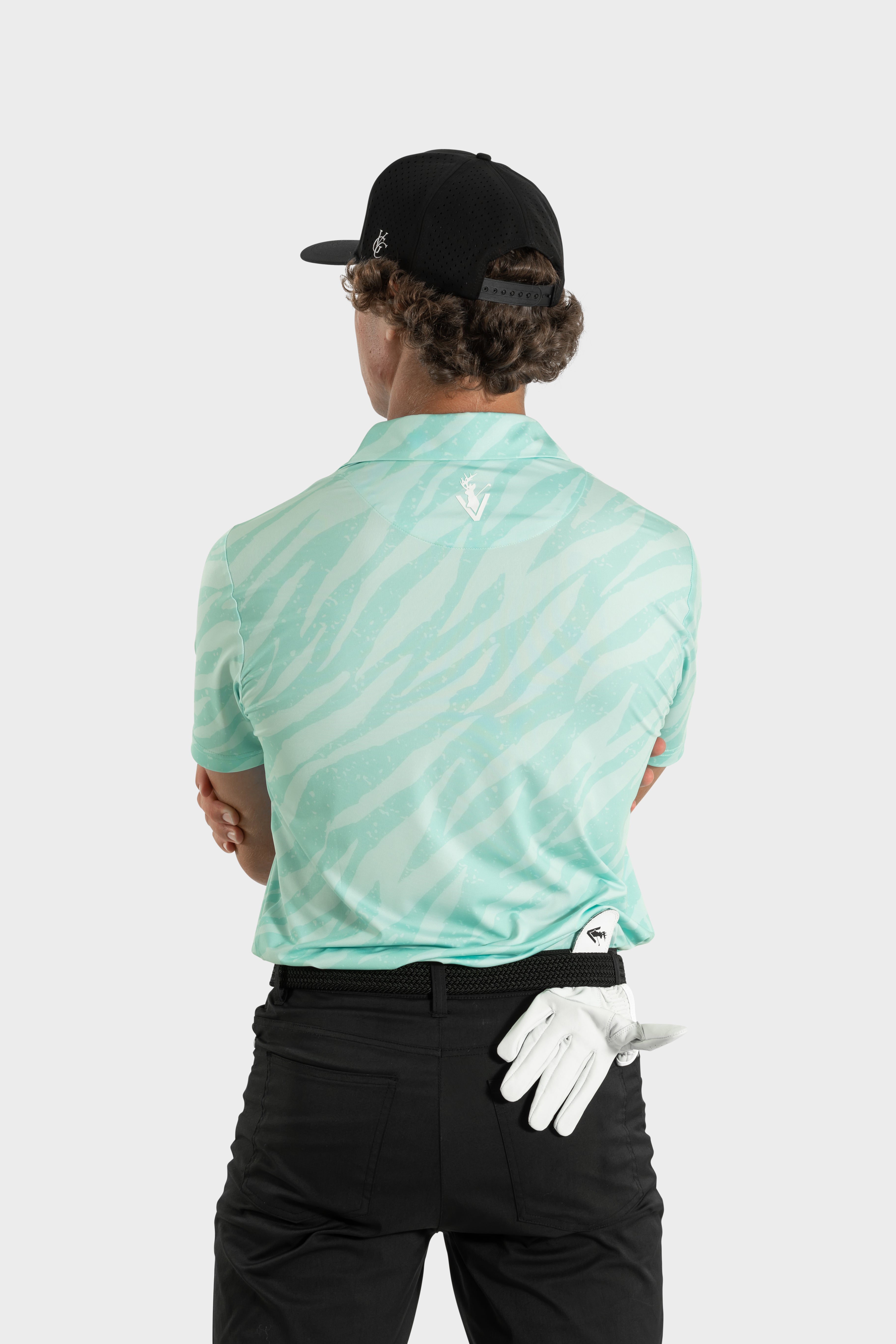 Man wearing The TigerMint mint-green polo shirt with zebra pattern and black pants from back view