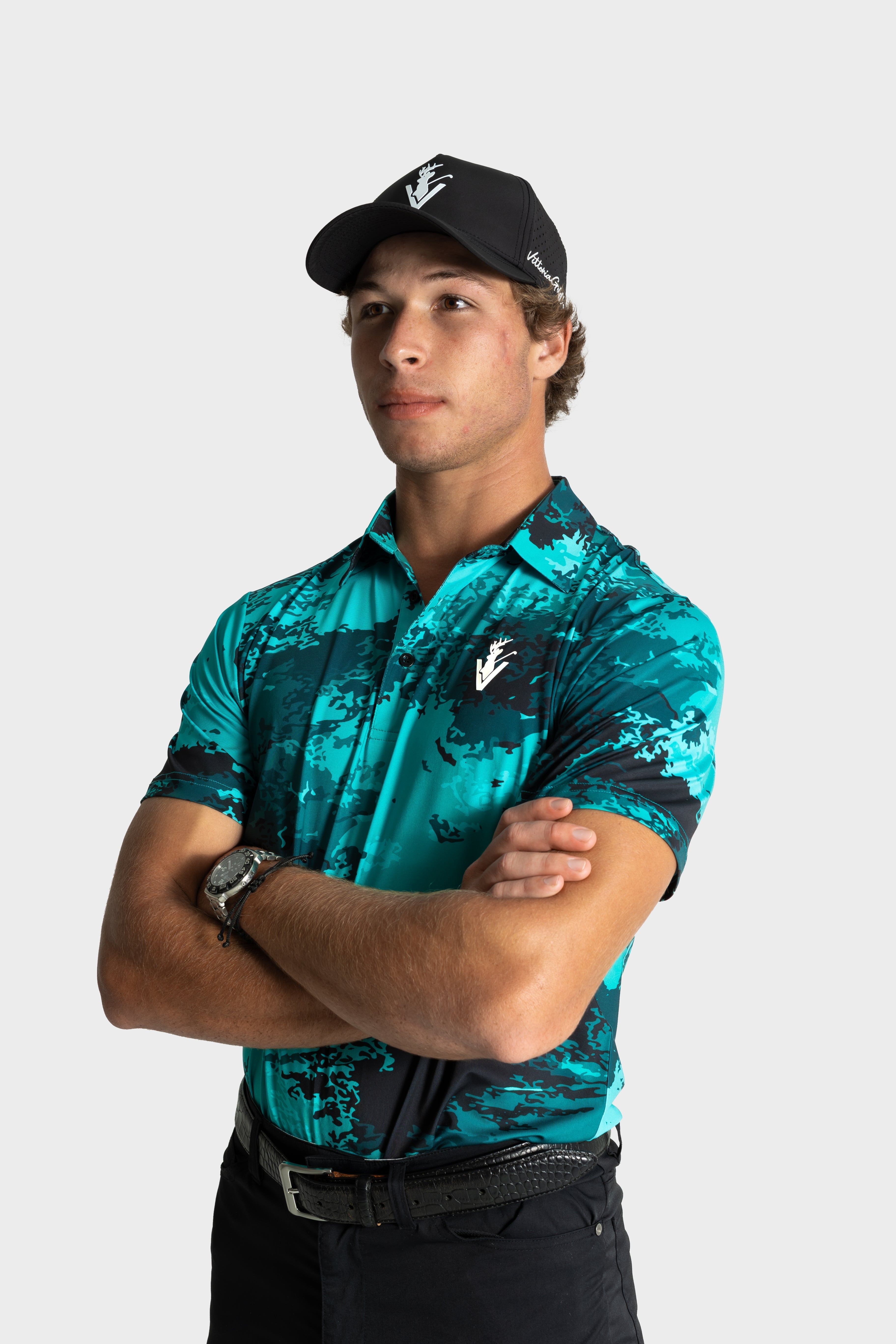 Man wearing The One polo by VittoriaGolfco in teal patterned design and black cap