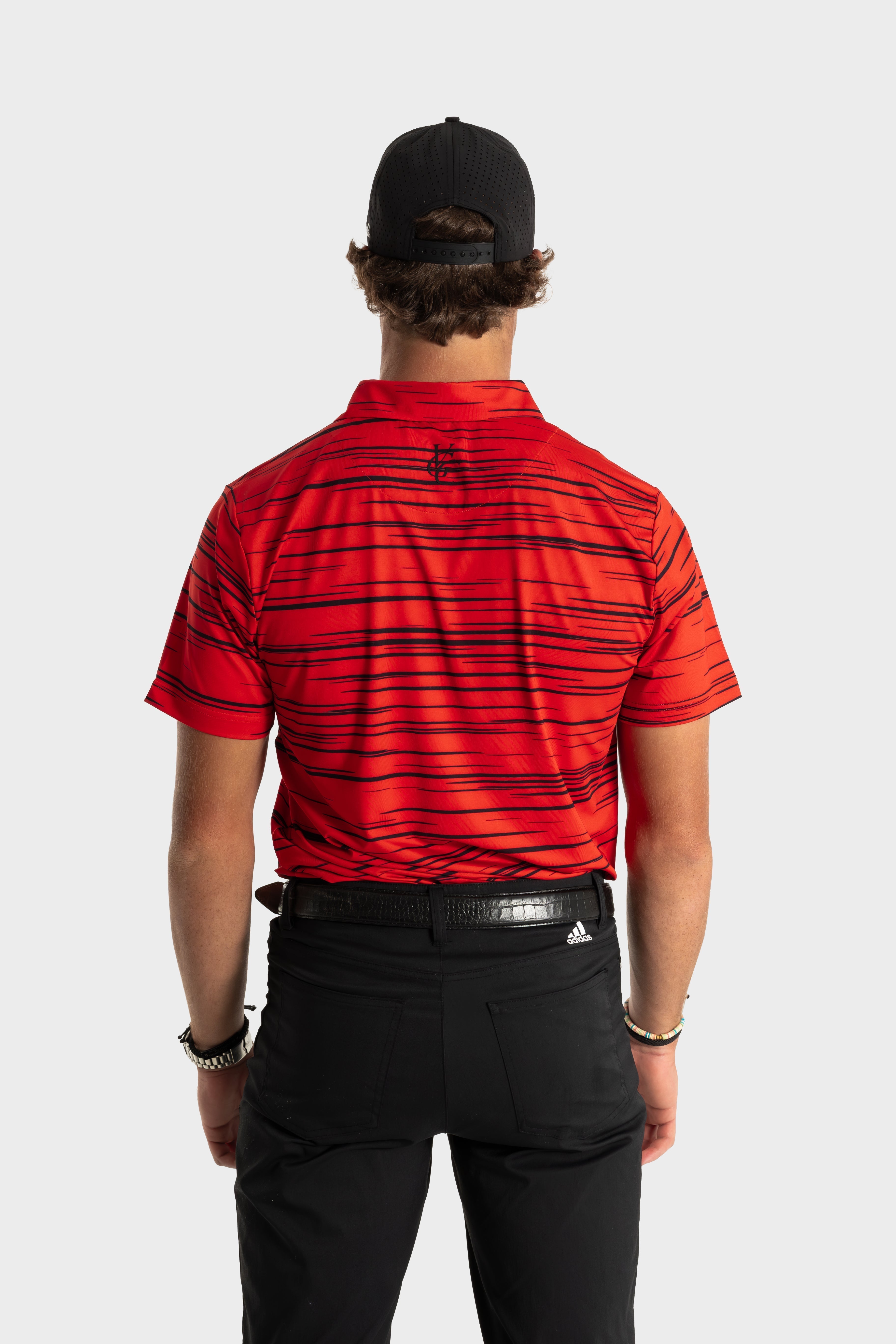Back view of man wearing red striped The Sunday Polo with black pants and black cap