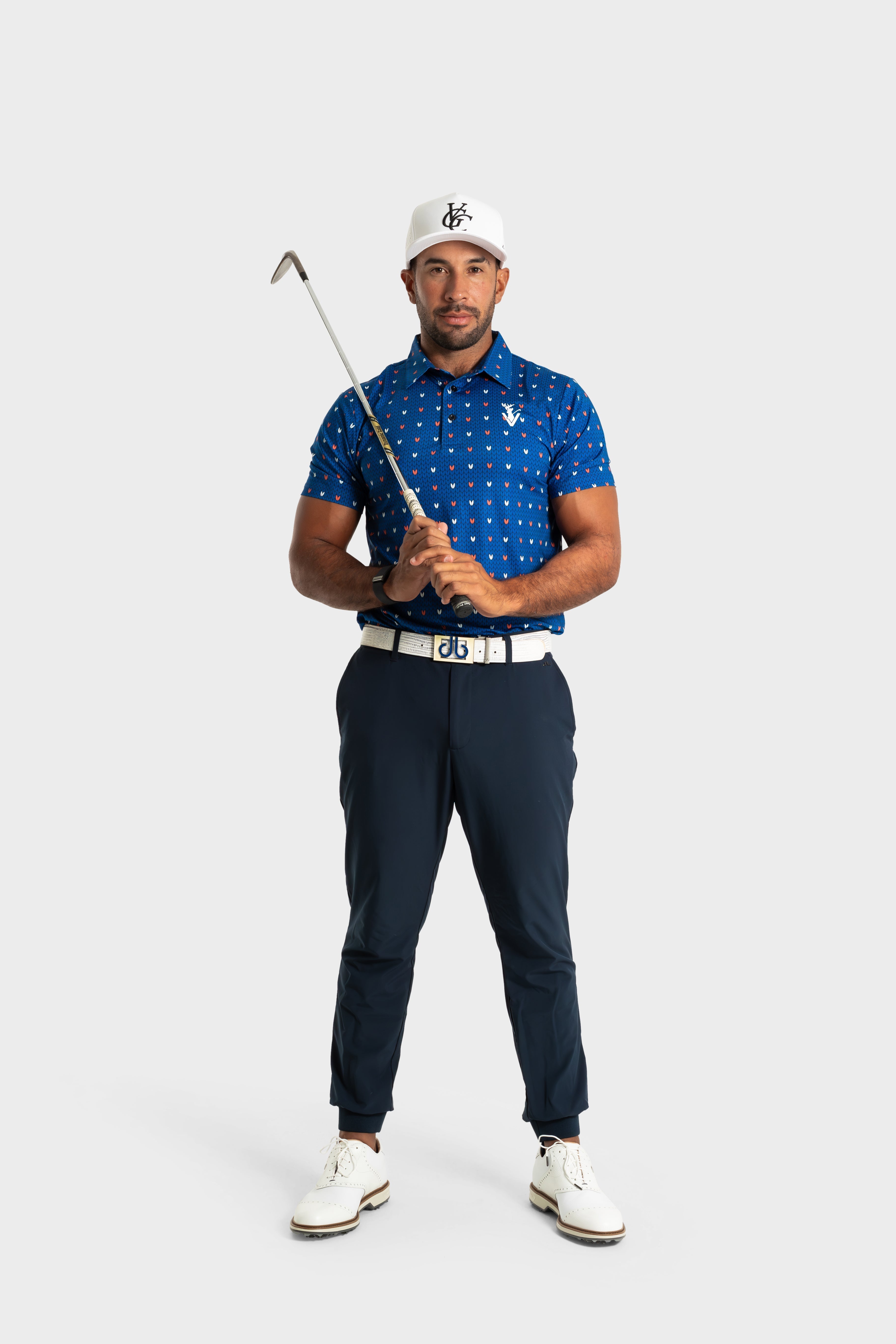 Male golfer wearing The Knitted polo in blue with patterned design holding golf club