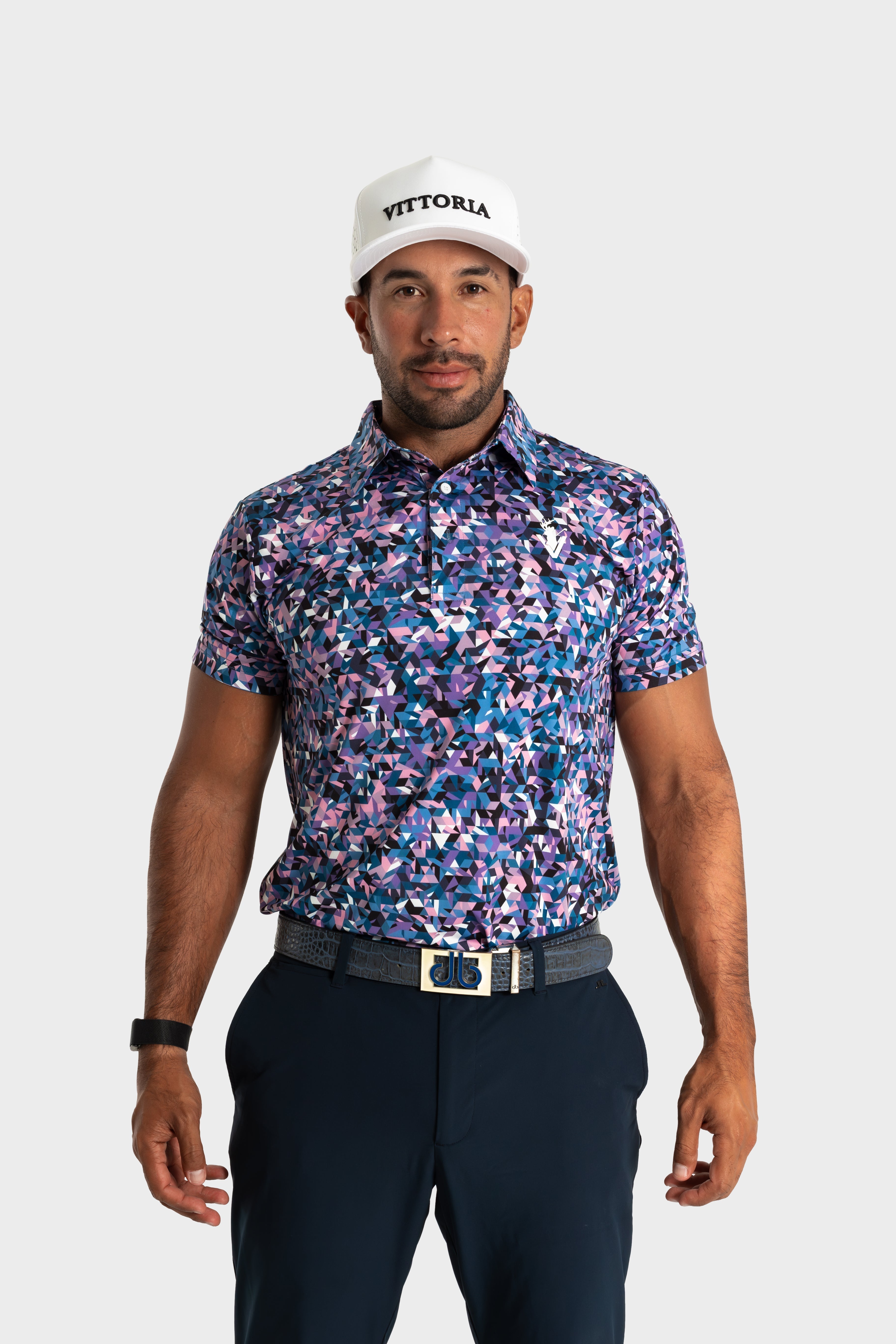 Man wearing The Geo polo with geometric patterns and navy pants on white background