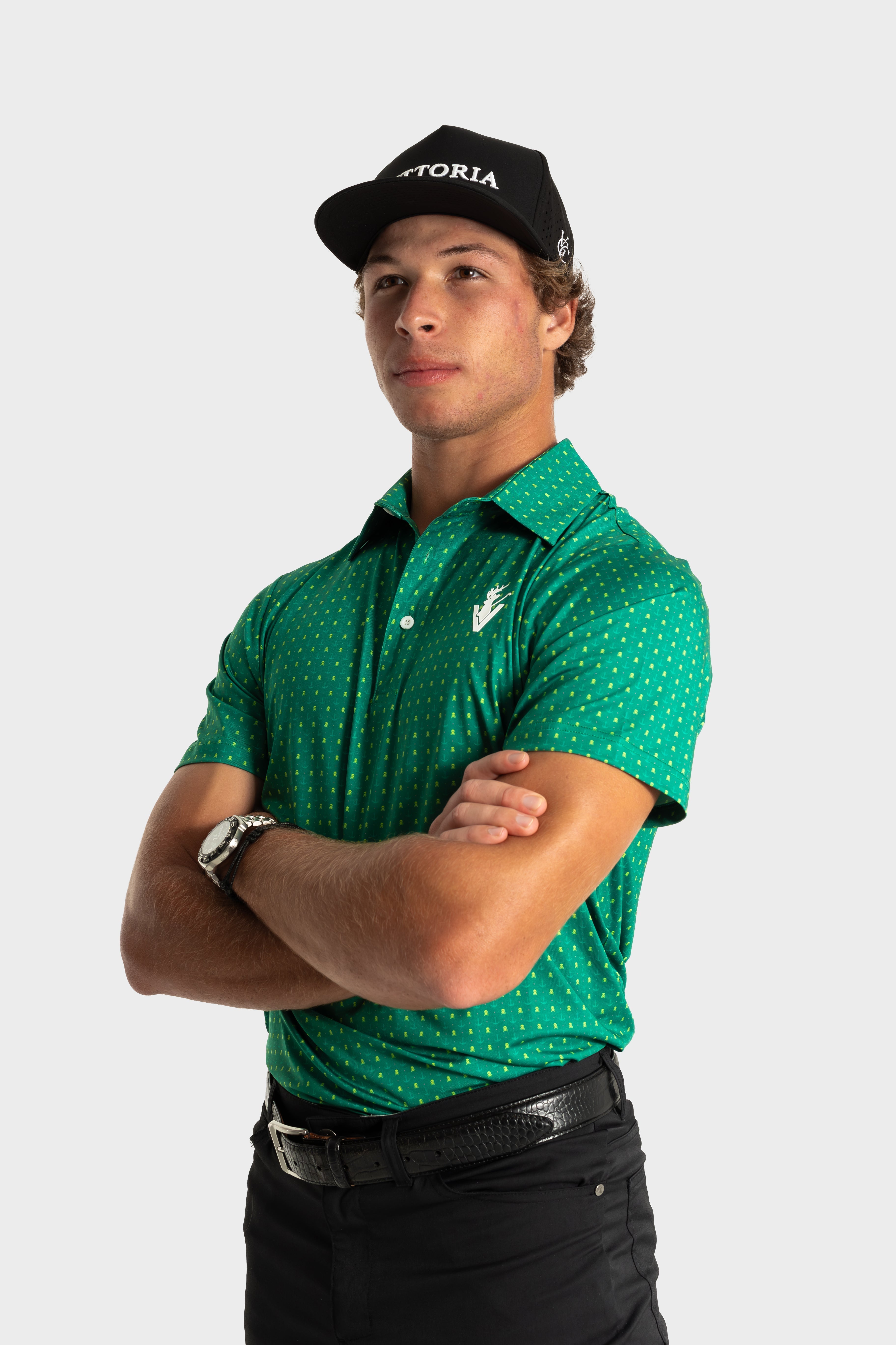 Man wearing green Skullzalea Golf Polo with tiny skull pattern and black cap
