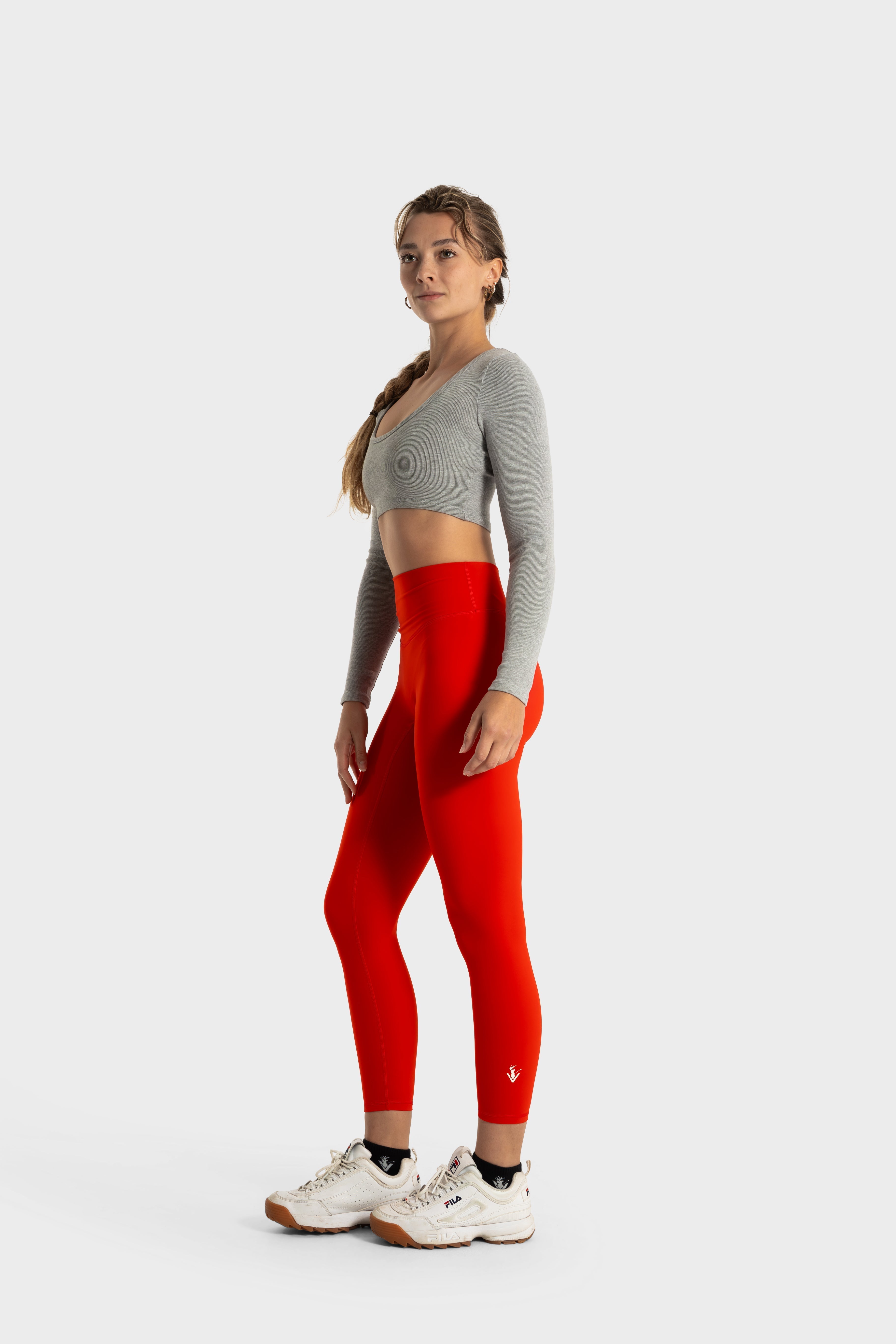 Woman wearing red Sollevare leggings and gray cropped top showcasing fit and support