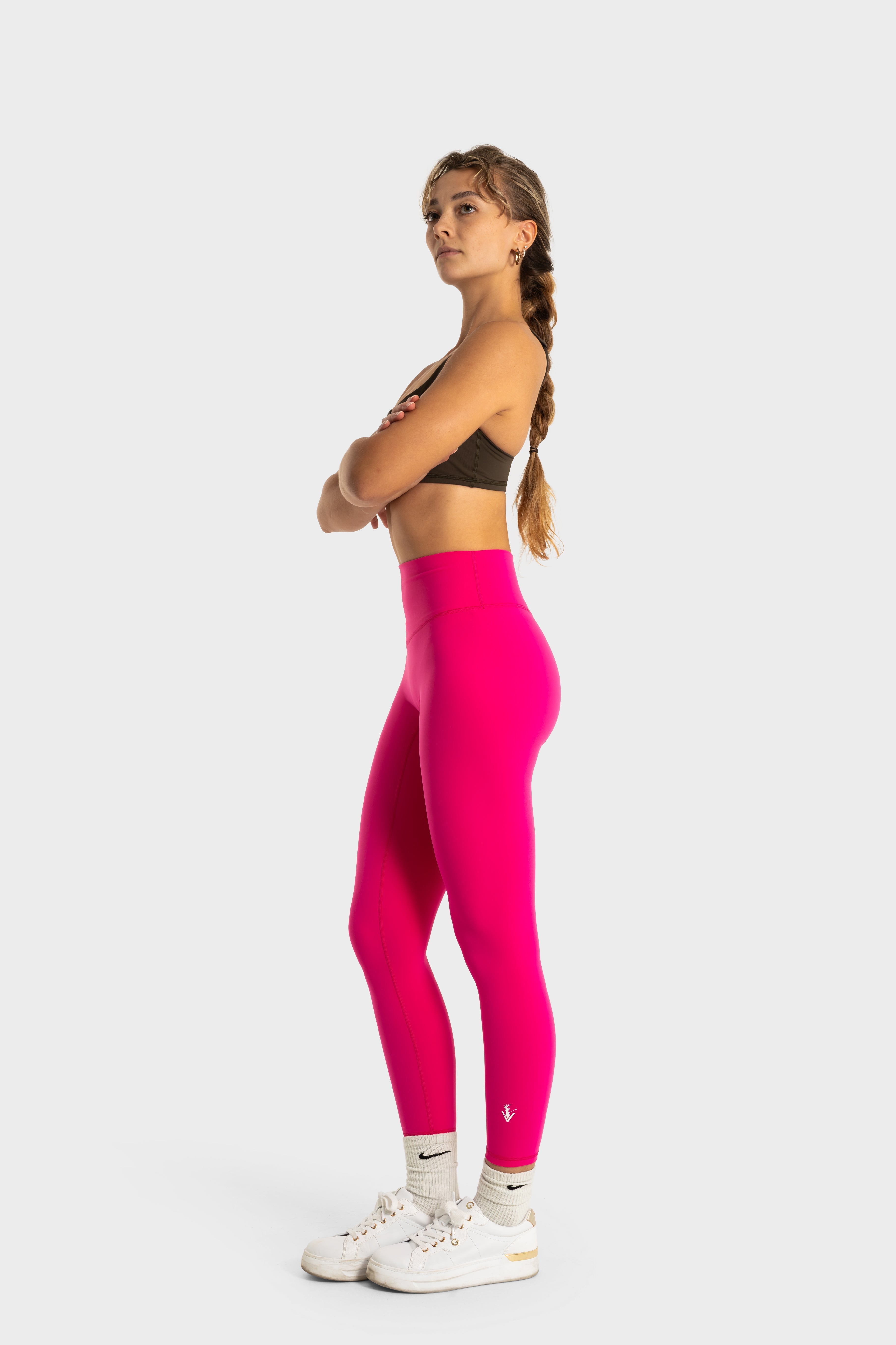 Woman wearing bright pink Sollevare leggings by VittoriaGolfCo with a high waist and supportive fit