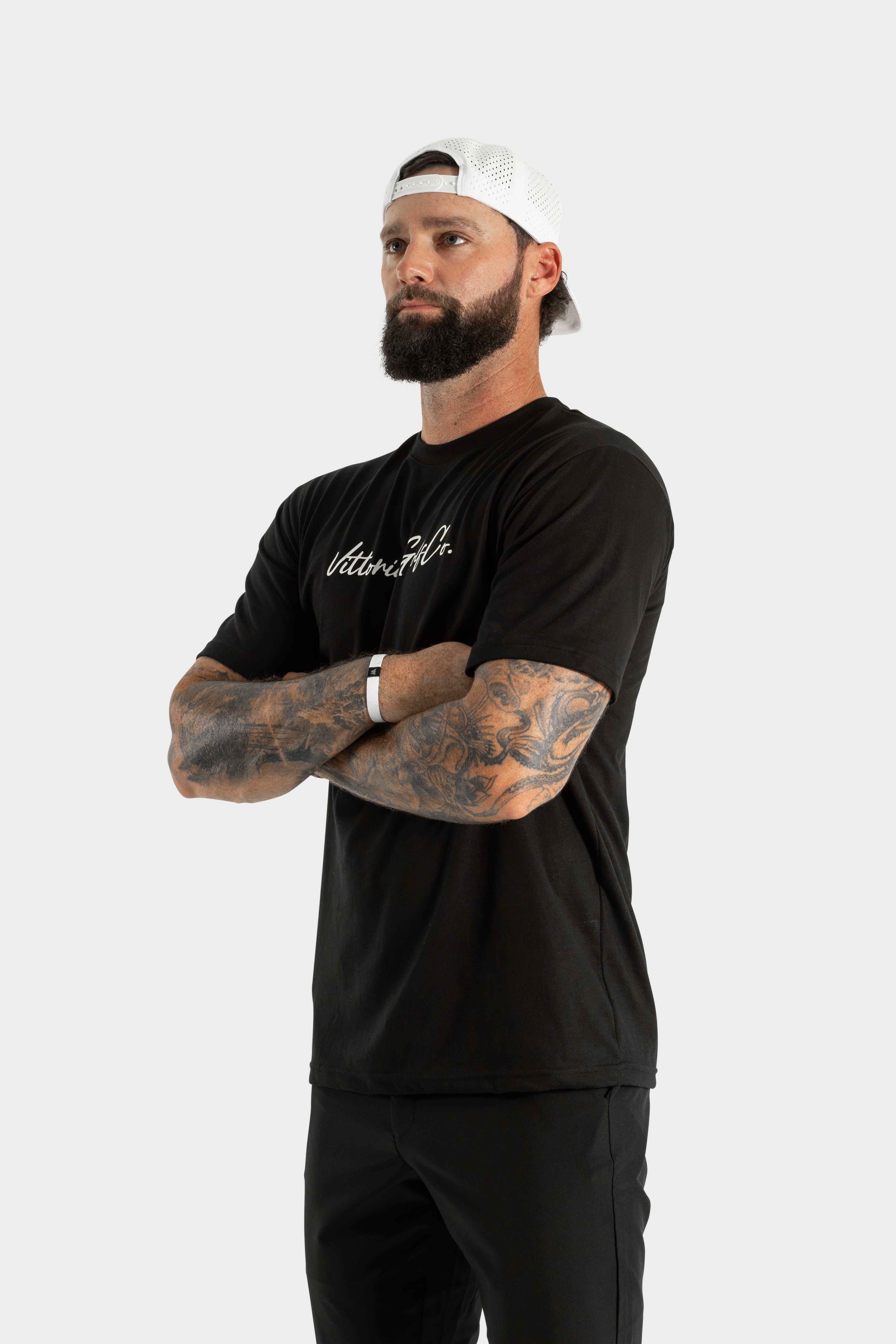 Man wearing black Vittoria Basic Tee with logo and white cap