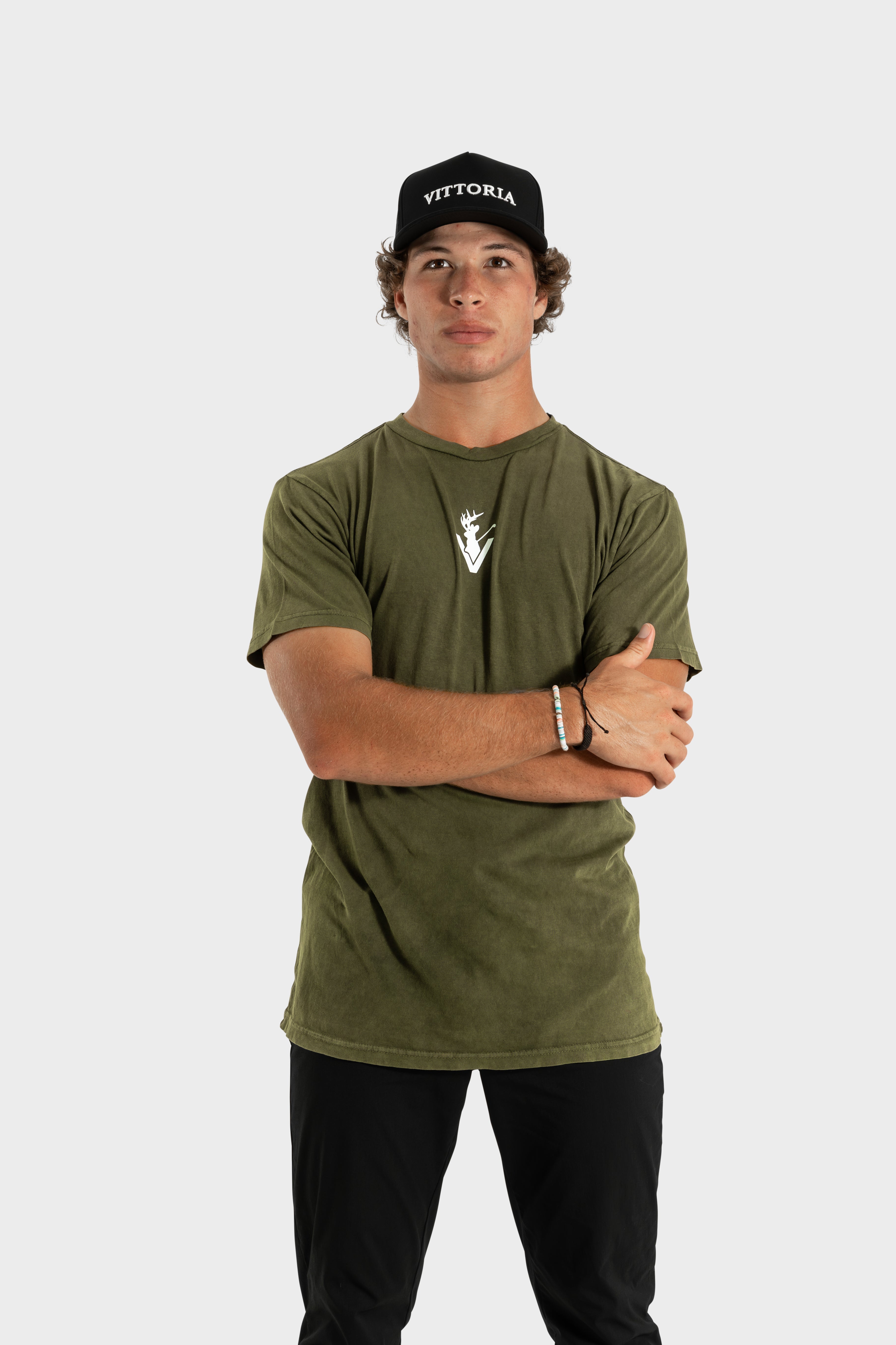 Man wearing olive green Vittoria Oversized Tee with logo and black Vittoria cap