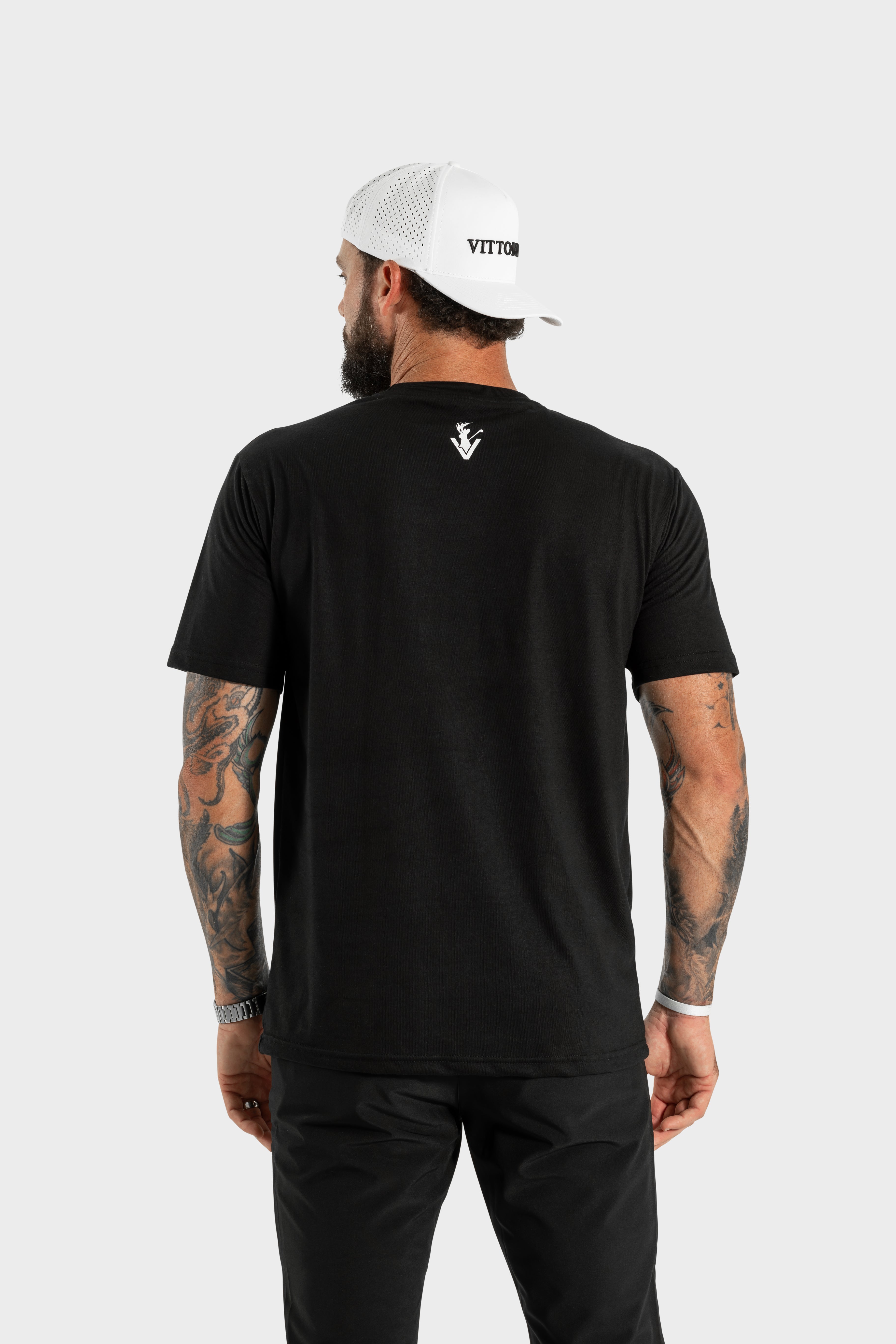 Back view of man wearing black Vittoria Basic Tee with logo on upper back and white cap