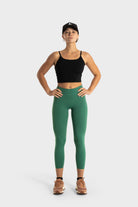 The Quelles green leggings by VittoriaGolfCo modeled by woman in black crop top and cap, showcasing flexibility and comfort.