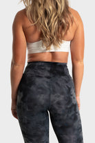 Back view of woman wearing The Quelles black patterned leggings by VittoriaGolfCo for active comfort and style