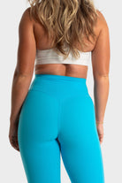 Woman wearing bright blue Sollevare leggings by VittoriaGolfCo showing rear view