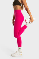 Woman wearing bright pink Sollevare leggings by VittoriaGolfCo showing targeted lift and support.